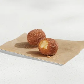 Menu 64 Cinnabon Delights® 2 Pack, dusted in cinnamon sugar and filled with Cinnabon® cream-cheese frosting.