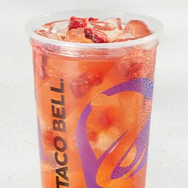 Strawberry Passionfruit Agua Fresca with freeze‑dried strawberry pieces, green tea base, and a fresh orange slice garnish in clear cup.